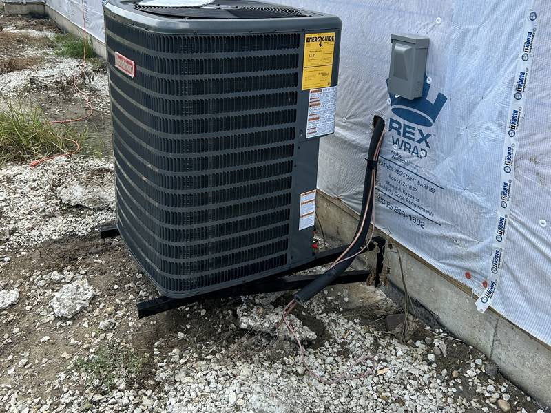 New central AC condenser on a wall bracket
