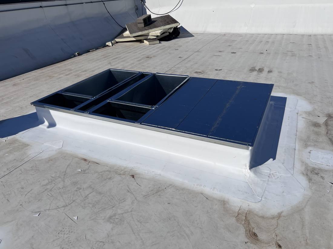 Curb adapter in place, blank-off panels closing the unused opening