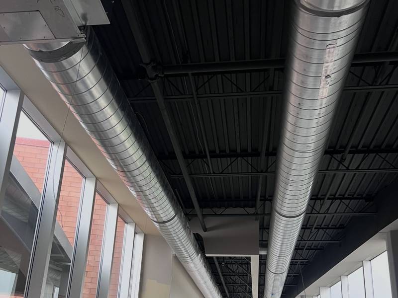 Spiral supply ductwork along a glass corridor
