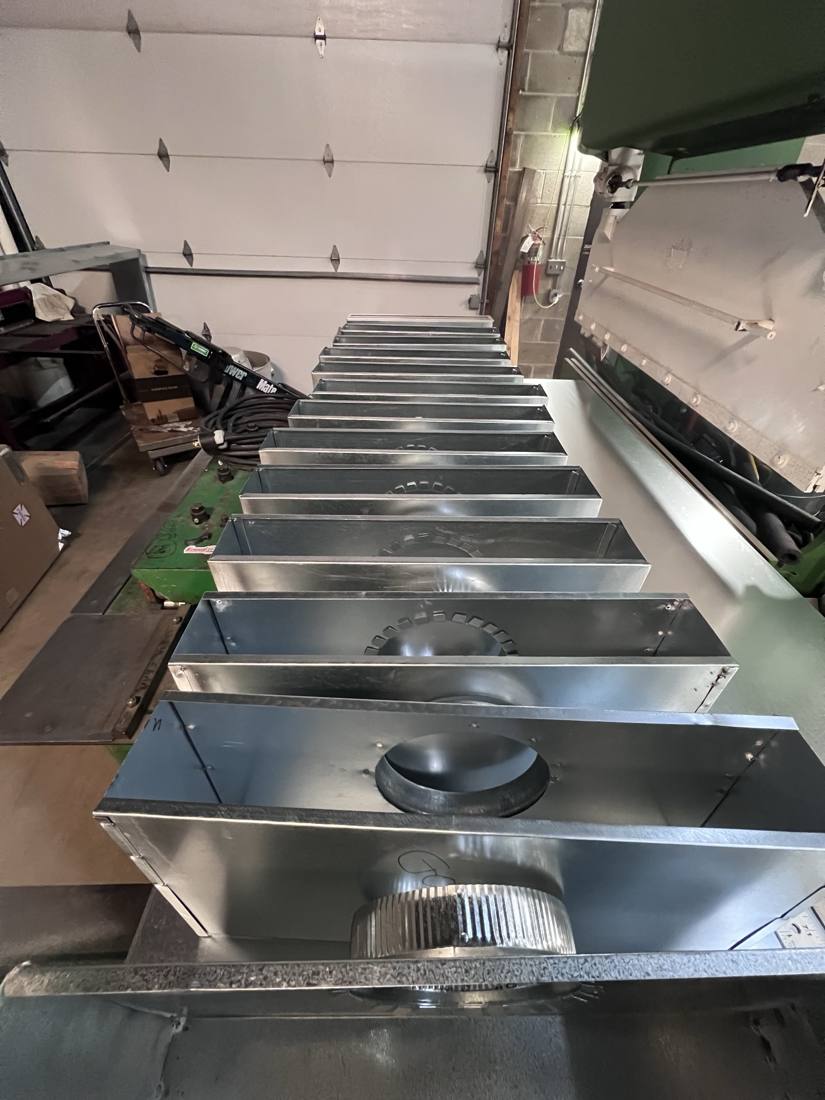 Plenum boxes with take-offs lined up on the bench